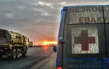 Poranek na drodze do Donbasu, z prawej bus z napisem „Bezpłatna ewakuacja”. 3 marca 2023 r. / ANTONINA PALARCZYK